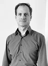 Ein Schwarz-Weiss-Foto eines Mannes in einem Hemd.